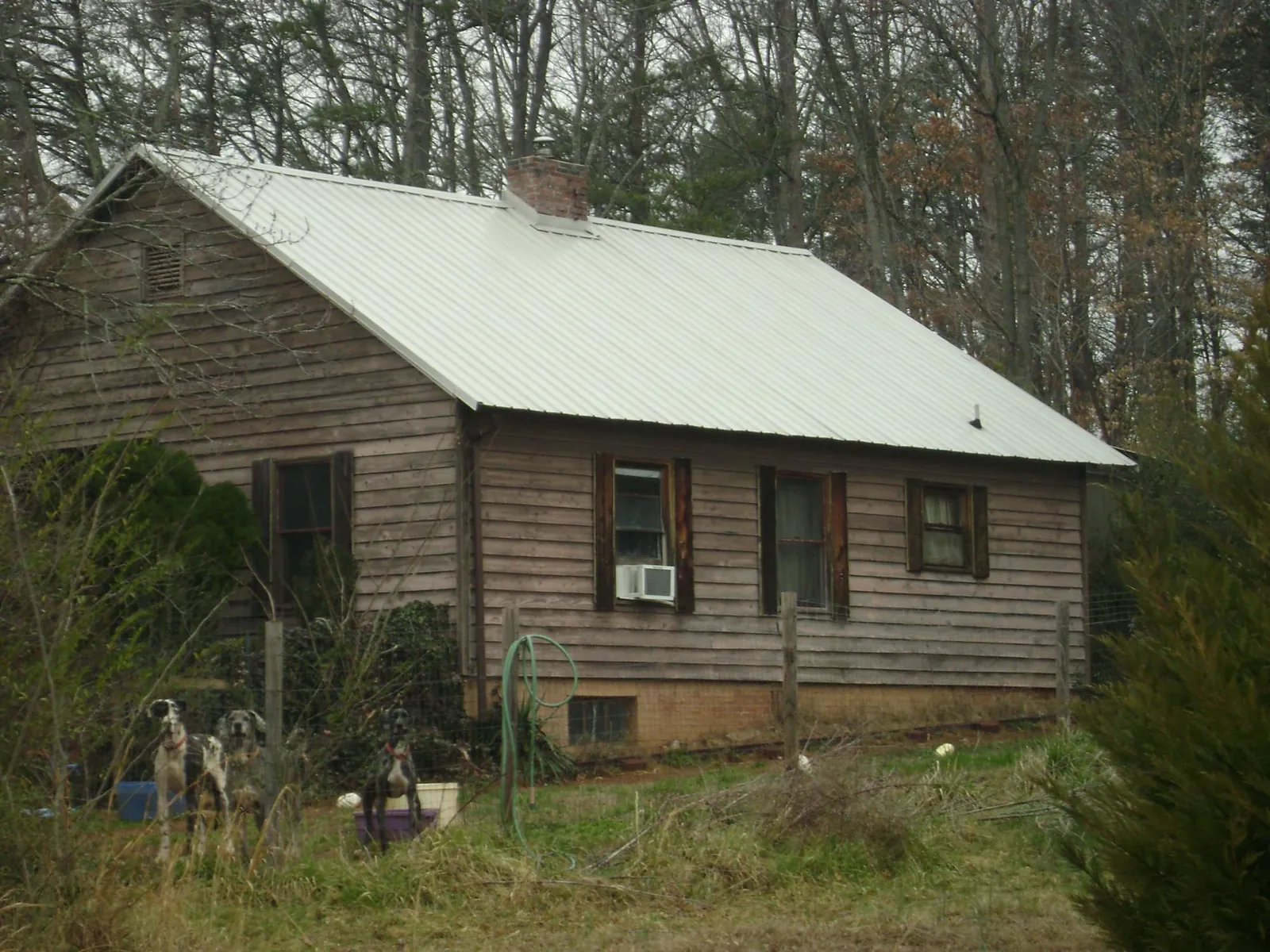 White metal roof on an old wood sided farmhouse, from a Metal Roof Installation job in Hiawatha
